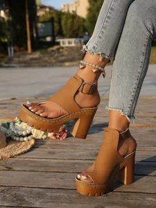 Detailed view of women's tan chunky high heel platform sandals with toe loop and buckle