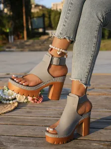 Detail of gray platform peep-toe sandals with thick wooden-style high heels.