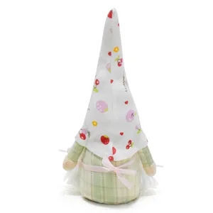 Detailed view of decorative plush gnome with fruit print hat and pink ribbon bow