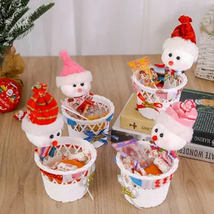 Detail von Weihnachts-Schneemann-Geschenkkörben gefüllt mit Süßigkeiten auf einem Holztisch.