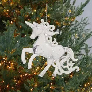 Nahaufnahme eines funkelnden, klaren Acryl-Einhorns, das an einem Weihnachtsbaum hängt