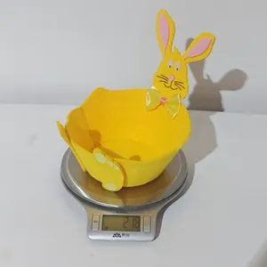 Osterhasen-Aufbewahrungskorb aus gelbem Filz auf einer Digitalwaage für leichtes Gewicht