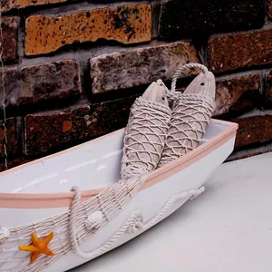 Detail view of nautical wooden boat decor with hanging fish and starfish accents.