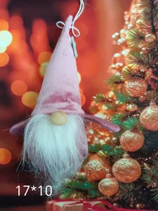 Detailansicht eines rosa Plüschwichtel-Ornaments vor festlichen Bokeh-Lichtern