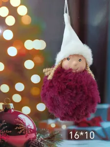 Close-up of a plush angel Christmas ornament with fuzzy pom-pom body and white hat