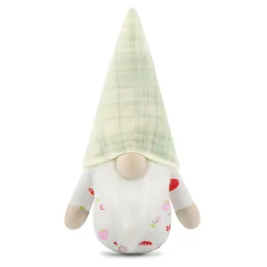 Detailed view of a plush Christmas gnome with green plaid hat and fruit patterned body