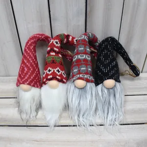 Gros plan de quatre ornements de gnomes de Noël tricotés avec de longues barbes blanches