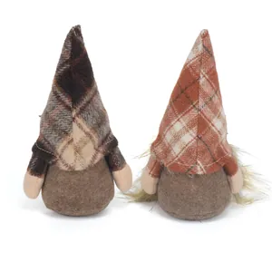 Vista posteriore di due gnomi autunnali in peluche con cappelli scozzesi e corpi marroni