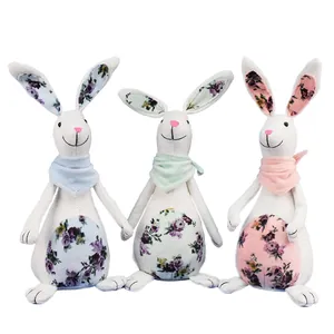 Close-up of three burlap Easter bunny figurines with floral patterns and scarves
