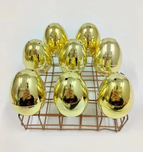 Collection of eight metallic gold plastic Easter eggs displayed on a copper wire rack.