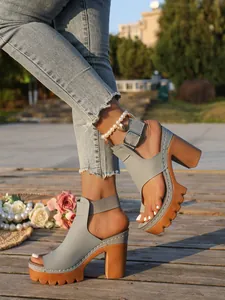 Detail view of grey chunky platform sandals with peep-toe and buckle strap on model
