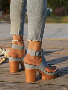 Side view of women's blue chunky platform sandals with buckle on sunset boardwalk