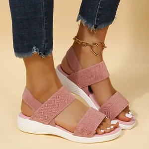 Sandalias de plataforma con cuña rosa para mujer con correa elástica y suela blanca.