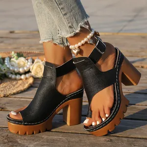 Close-up of black chunky high heel sandals with platform sole and buckle detail