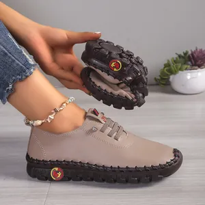 Detailopname van flexibele beige leren loafers met handgestikte rubberen zool die ombuigt.