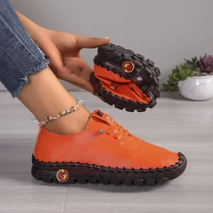 Gedetailleerde weergave van oranje leren loafers die extreme flexibiliteit tonen