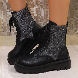 Dettaglio di stivaletti neri con plateau, pannelli glitterati e lacci per donna.