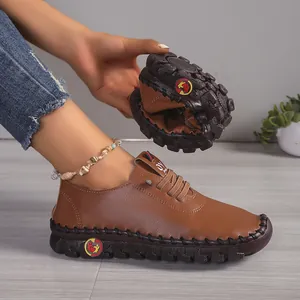 Close-up van flexibele bruine leren loafers met gestikte rubberen zool voor dames