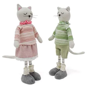 Détail de deux mignonnes poupées chats en tissu avec tenues à rayures pour la décoration.