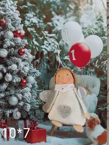 Detailed view of a plush Christmas angel ornament with silver glitter heart and wings