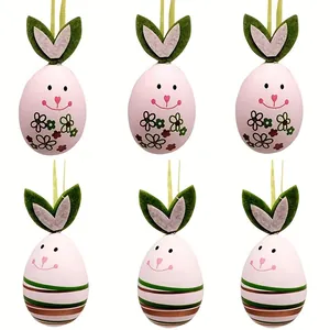 Set mit sechs rosa Ostereier-Anhängern mit niedlichen Hasenohren und bunten Blumenmustern