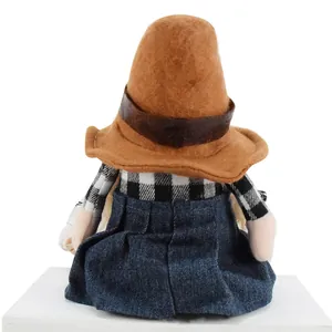 Rear view of a plush denim girl gnome doll with a tall brown hat and plaid shirt.