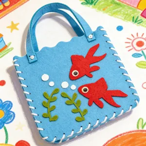 Detalle de bolso DIY de fieltro azul para niños con motivos de peces rojos