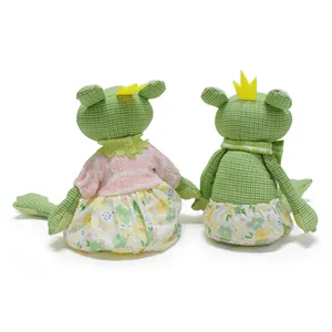 Vue arrière de deux poupées grenouilles en tissu fait main avec robes à fleurs et couronnes.