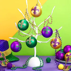 Close-up of 6cm Mardi Gras decorative balls with glitter Fleur-de-lis patterns on a white tree.