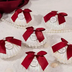 Eleganti scatole per caramelle a conchiglia bianco perla con fiocchi rossi per regali.
