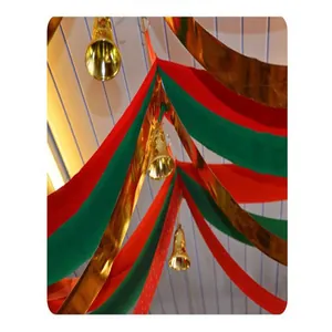 Decoración festiva de techo de Navidad con cintas ondeantes rojas verdes y campanas doradas