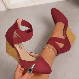 Detailed macro view of wine red pointed toe wedge sandals with elastic cross straps