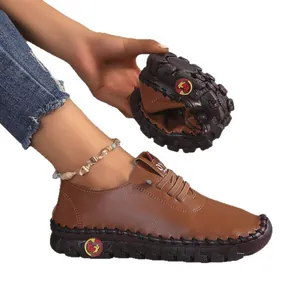 Comfortabele bruine zachte leren damesschoenen met flexibele rubberen zool en stiksels.