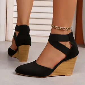 Detail showing black pointed toe wedge sandals featuring elastic cross-over ankle straps