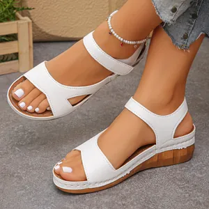 Detailopname van stijlvolle witte sandalen met sleehak en comfortabele dikke houten zool