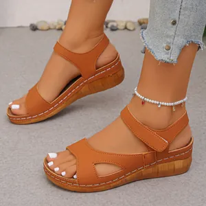 Detailopname van de witte stiksels op stijlvolle bruine sandalen met sleehak en een parel-enkelband.