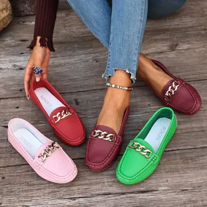 Close-up detail showing colorful women's loafers with gold chain on a wooden background