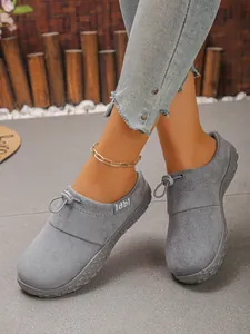 Detailed macro view of grey soft textile slip-on shoes featuring a front bungee lace design