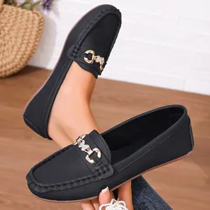 Macro detail of black leather loafers featuring a sparkling metal buckle ornament
