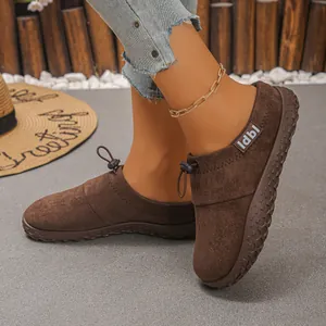 Close-up of vintage brown suede-like loafers with front drawstring and label detail
