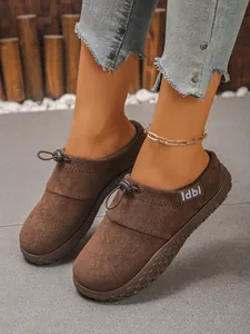Close-up of brown suede women's slip-on loafers with decorative toggle drawstring