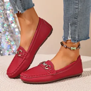 Close-up of elegant red leather loafers with stylish metal buckle detail for women