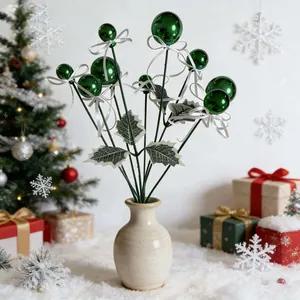 Detail view of green Christmas ball picks with white ribbons and holly leaf decorations.
