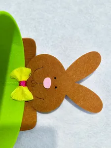 Detail shot of a green Easter felt storage basket with a brown cartoon rabbit and bow.