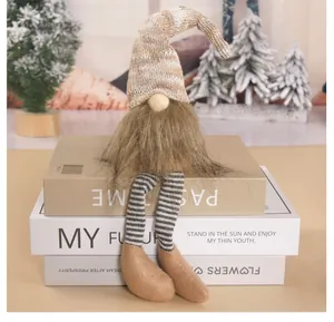 Vue détaillée d'un gnome de Noël assis avec de longues jambes rayées et une barbe