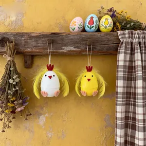 Detalle de adornos colgantes de huevos de pollito de Pascua con plumas amarillas y blancas