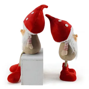 Vista laterale di due gnomi di Natale con cappelli a fungo rossi e lunghe barbe bianche.