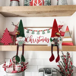 Two festive Christmas gnomes with long hanging legs and holiday ornaments