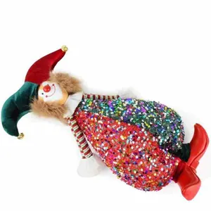 Detalle de un muñeco payaso con lentejuelas de colores y botas rojas de decoración.