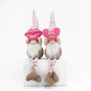 Primo piano di due gnomi di peluche per la festa della mamma con cuscini a cuore e labbra.